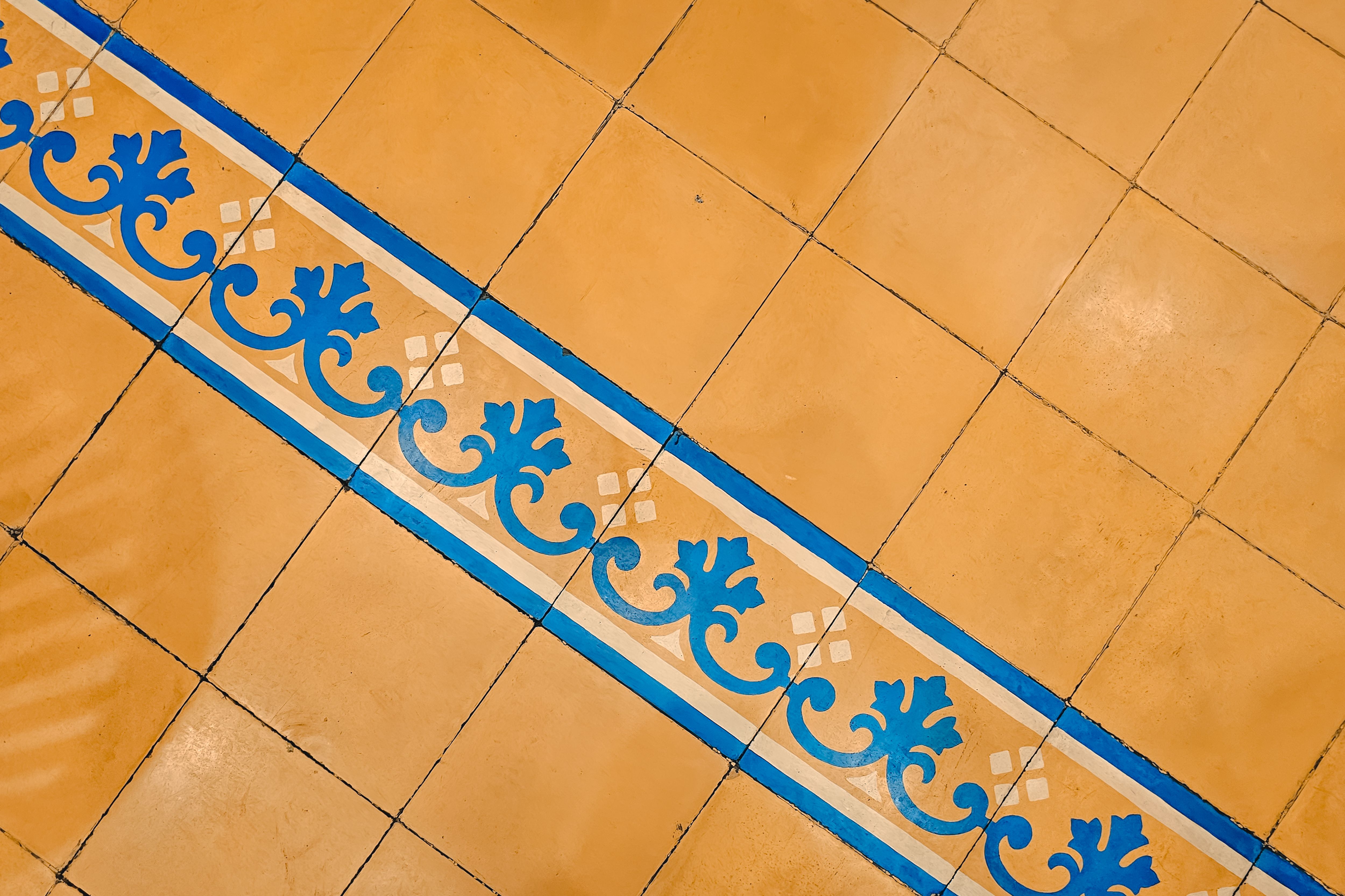 Central Java tile design with blue ornate pattern on yellow background, ideal for decor inspiration.