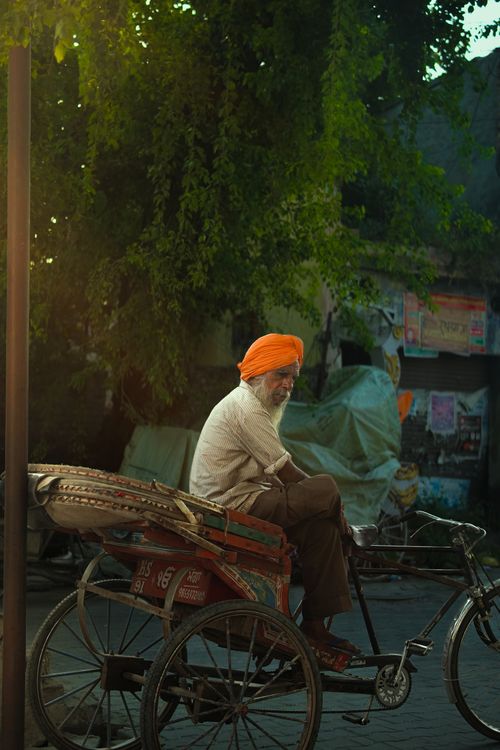 Free A serene street scene in Moga, India depicting an elderly Sikh man on a rickshaw. Stock Photo