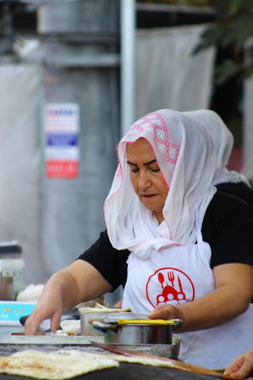 Free A Middle Eastern woman preparing traditional food at an outdoor market. Stock Photo