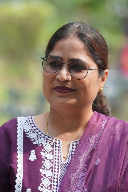 Free Close-up portrait of a woman smiling outdoors in a purple traditional outfit. Stock Photo