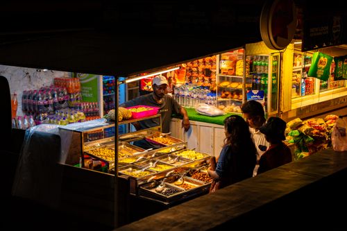 Free Street food stall in Colombo, Sri Lanka, bustling with people at night, offering a variety of dishes. Stock Photo