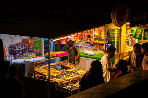 Free A bustling street food stall in Colombo, Sri Lanka, illuminated at night with people buying snacks. Stock Photo