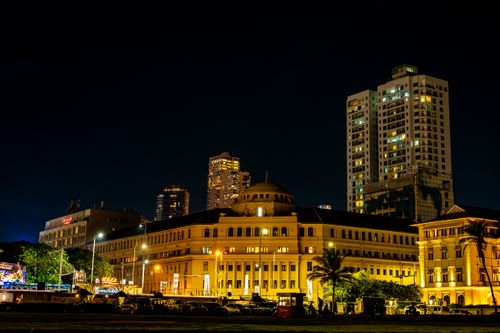 Free Stunning nighttime view of Colombo's colonial architecture with illuminated skyscrapers in the background. Stock Photo