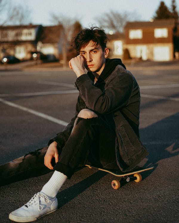 A Man Sitting on a Skateboard