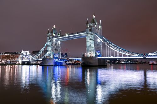Free A stunning view of London's Tower Bridge illuminated at night, reflecting on the Thames. Stock Photo