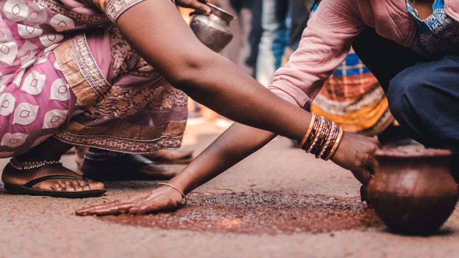 Close-up of hands crafting pottery on the street in Odisha, India.