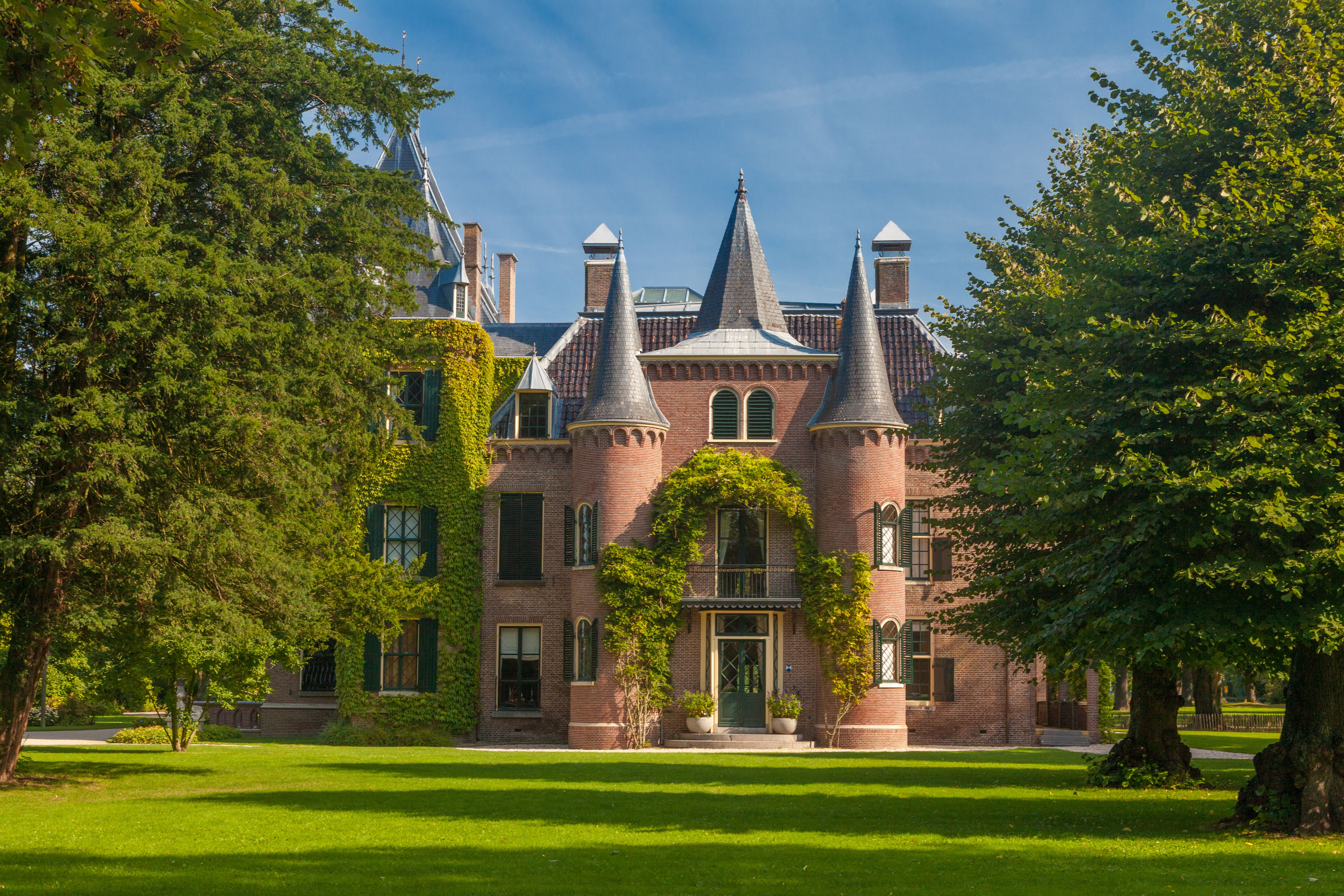 Charming historical castle with ivy-covered walls and lush green surroundings in Lisse, Netherlands.
