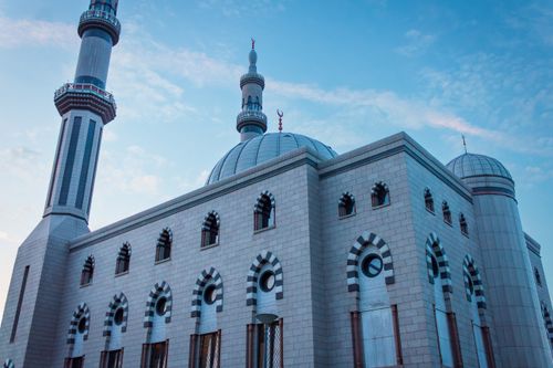 Free Stunning view of a mosque's intricate architectural details and towering minarets against a clear sky. Stock Photo