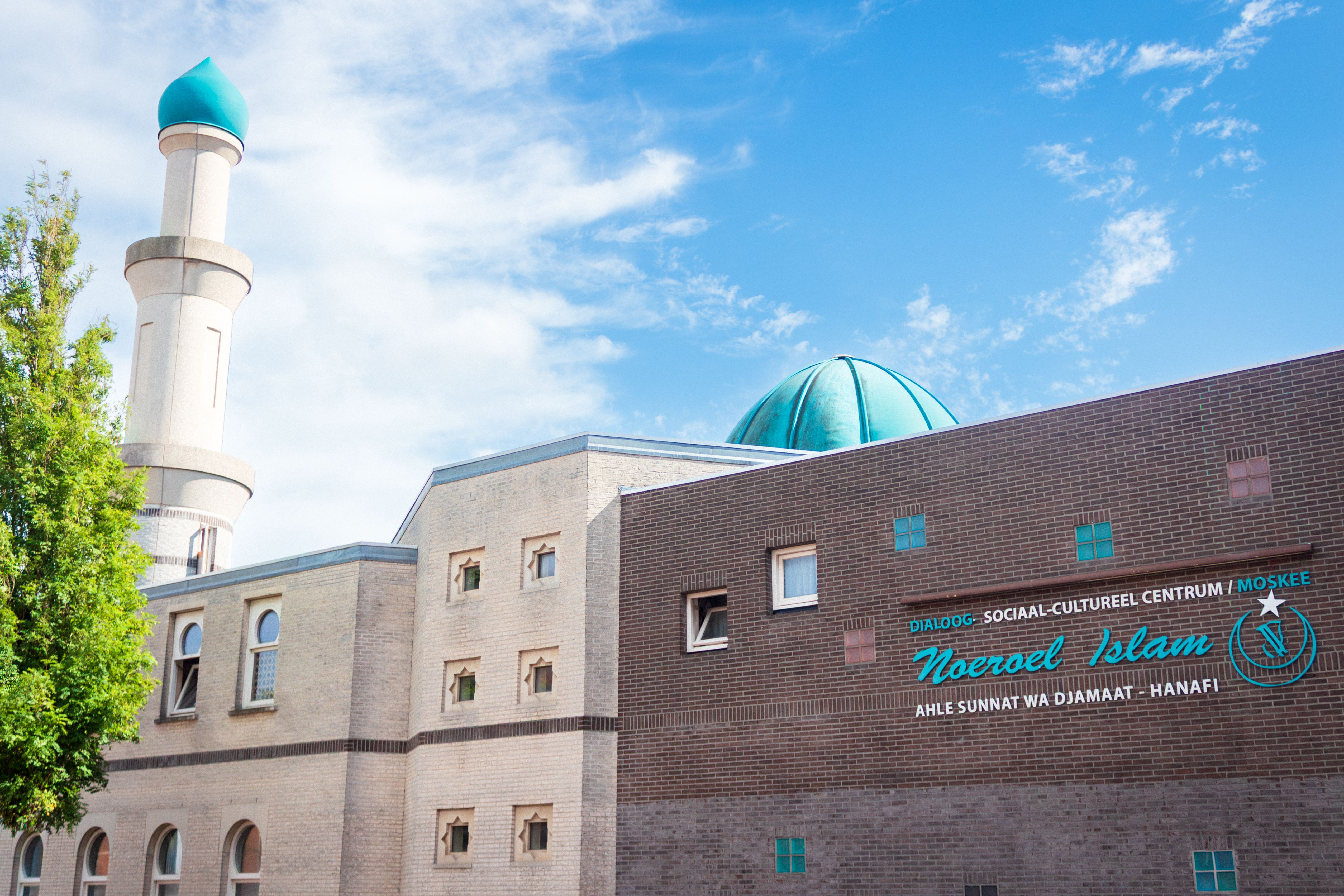 A modern mosque featuring a minaret and green dome under a clear blue sky, symbolizing cultural diversity.
