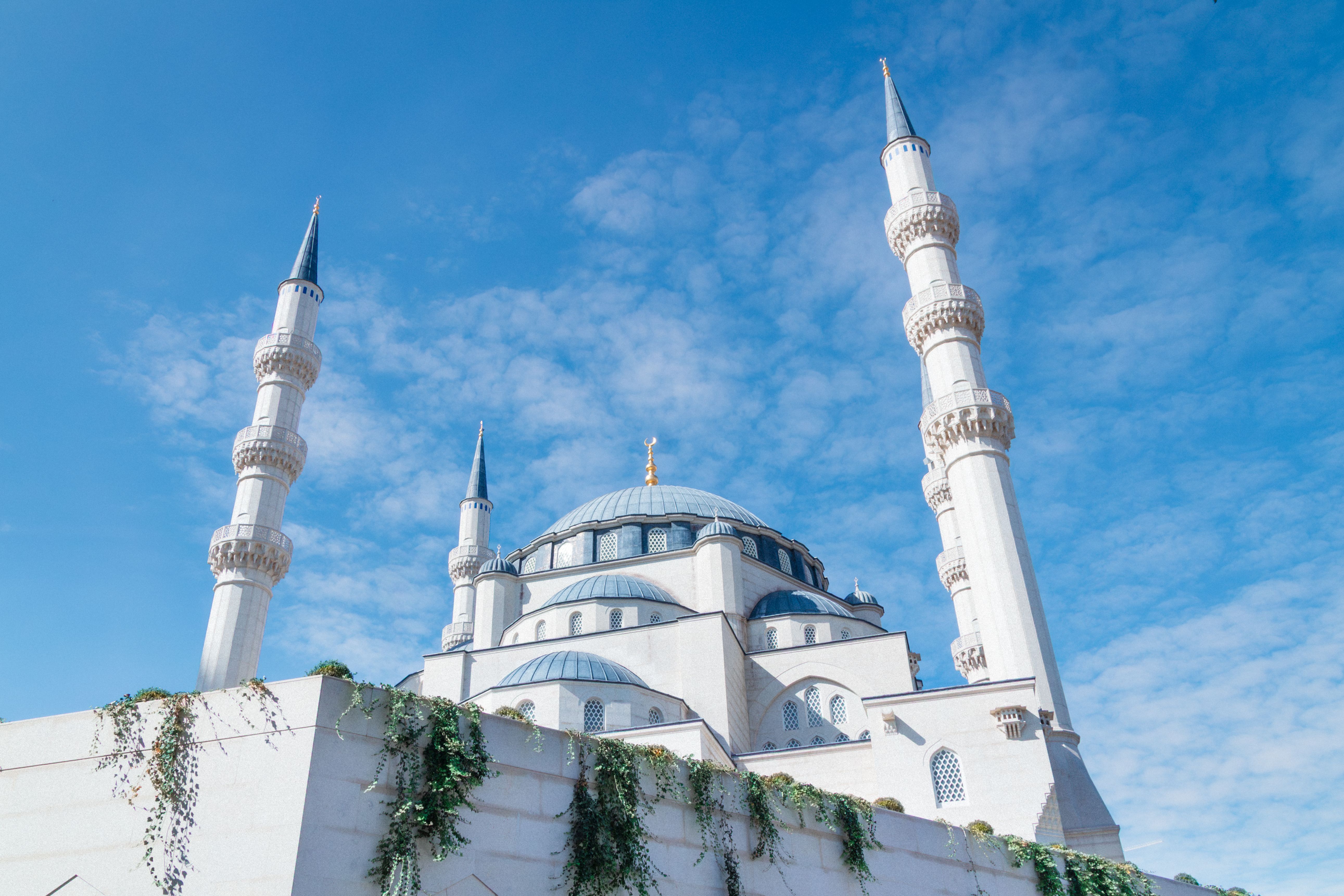 A stunning view of a mosque with tall minarets under a vivid blue sky.
