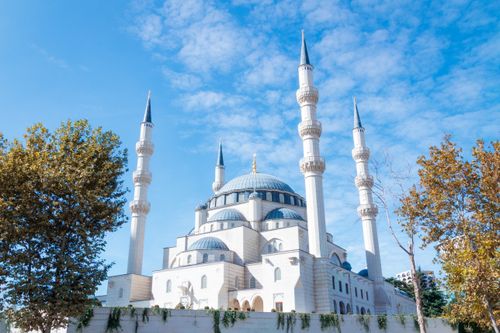 Free Elegant mosque with towering minarets set against a vibrant blue sky, showcasing intricate architecture. Stock Photo