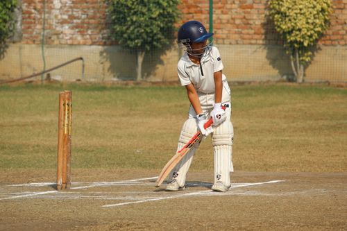 Free A young cricketer in batting stance on a sunny day in Gurugram, India. Stock Photo