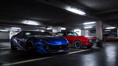 Free Blue Ferrari and red Pontiac parked in an underground garage. Stock Photo