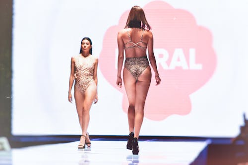 Free Models in Animal Print Swimwear Walking on Runway Stock Photo