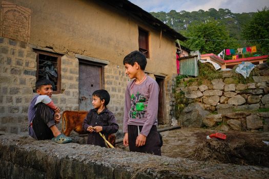 Three children enjoy a playful moment in a rural village in Dharamshala, India.