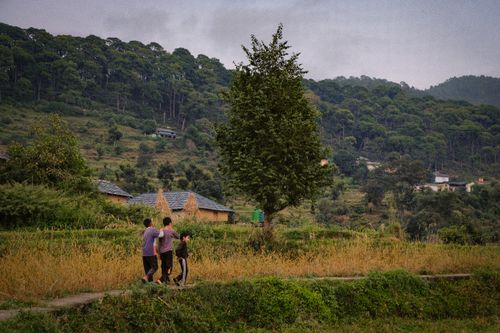 Free Three people walking in a tranquil village setting in Dharamshala, Himachal Pradesh, India. Stock Photo