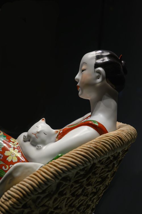 Free Artistic ceramic sculpture depicting a serene woman holding a cat. Stock Photo