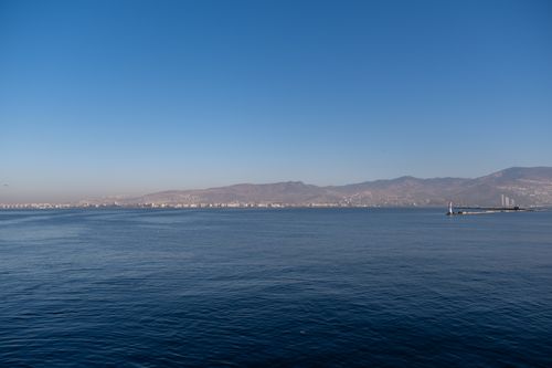 Free Serene landscape of İzmir's coastline with mountains and clear blue sky over the Aegean Sea. Stock Photo