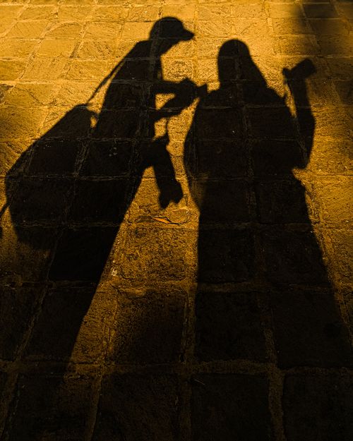 Free Shadows of two people against sunlit cobblestone pavement in Bandung, creating a unique artistic effect. Stock Photo
