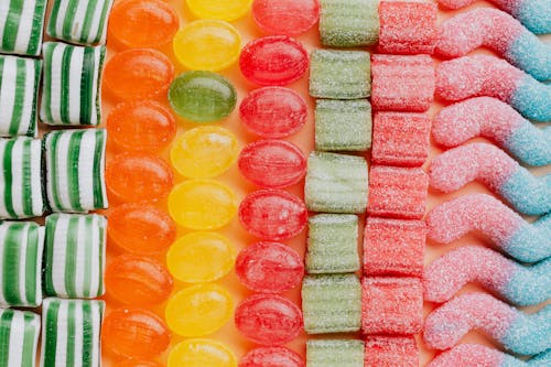 Set of delicious jelly and caramel sweets arranged in lines by type