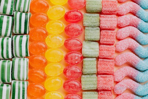 Free From above of various delicious jelly and caramel sweets arranged in rows by type and color in modern candy store Stock Photo