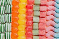 在现代糖果店里，各种美味的果冻和焦糖糖果按类型和颜色从上到下整齐排列