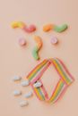 Top view of different gummy worms dragees and candies arranged together as yelling face in modern confectionery shop