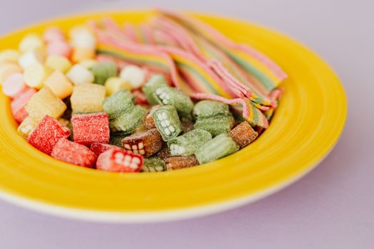 黄色盘子上，色彩缤纷的糖果特写镜头非常适合甜食爱好者
