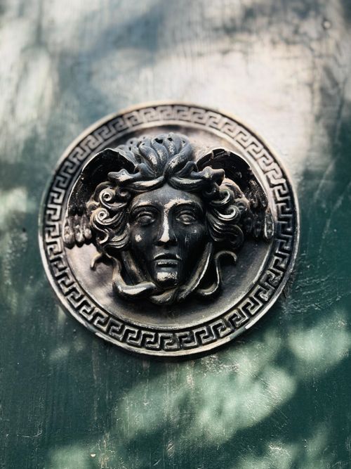 Free Close-up of Medusa face ornament on a door, showcasing intricate design and Greek symbolism. Stock Photo