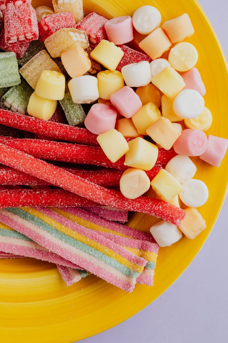 Top View Of Marmalade Sweets In Yellow Plate Over Gray Background