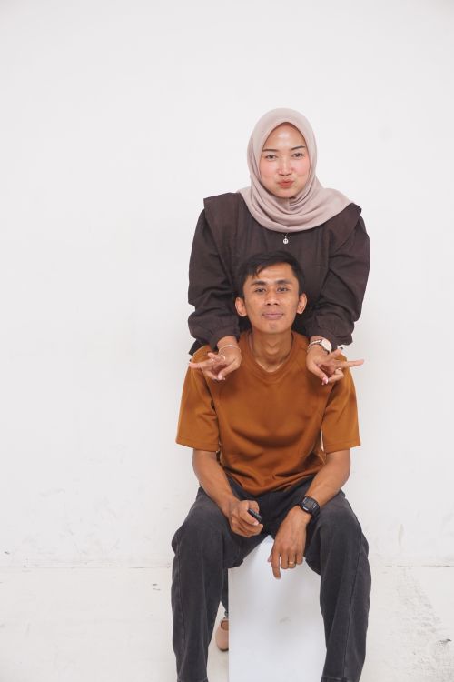 Free A cheerful couple posing playfully, conveying warmth and happiness in a studio setting. Stock Photo