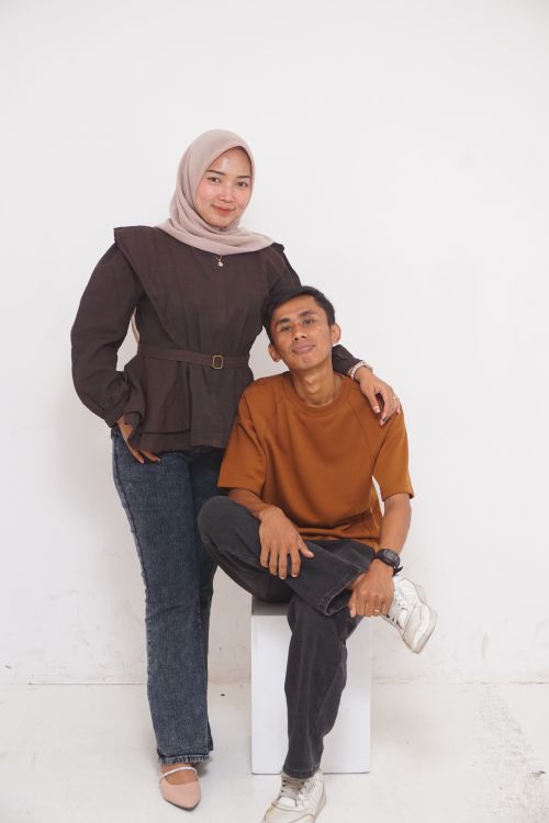 Free A couple posing in a casual and relaxed manner in a simple studio setting. Stock Photo