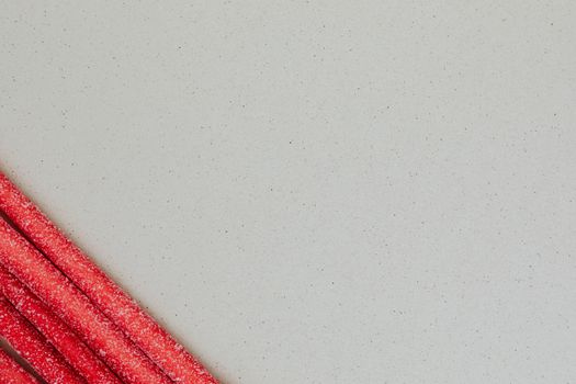 Long red chewy marmalade candy on gray background
