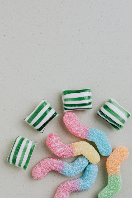Top view of multicolored chewy candies on gray background