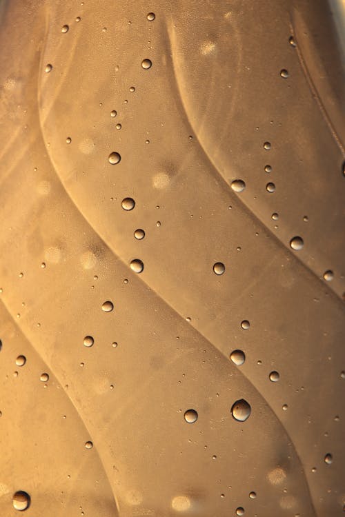 Free Water Droplets on Gold Surface Stock Photo
