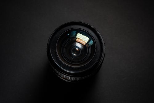 Free Detailed close-up of a camera lens with reflection on black background. Stock Photo