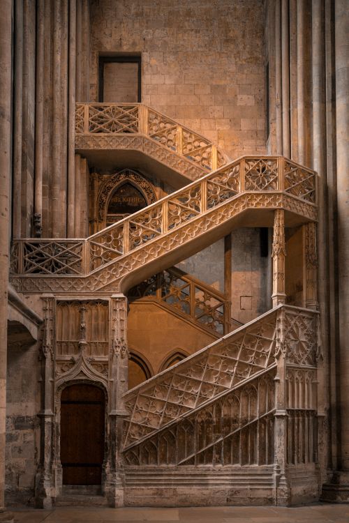 Free Detailed view of a historic Gothic spiral staircase with intricate stone carvings in an ancient church. Stock Photo