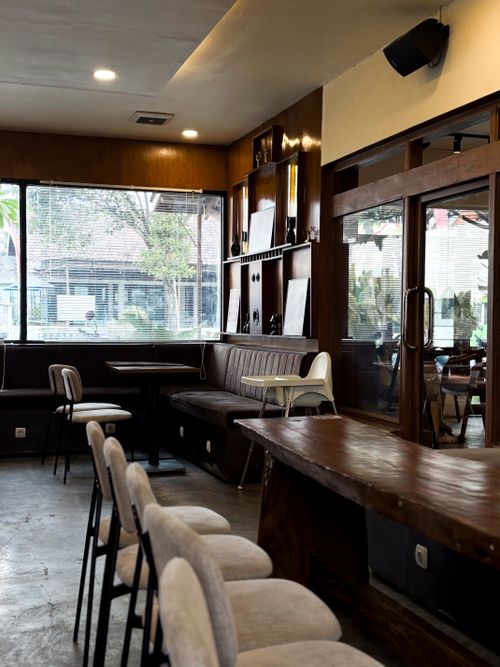 Free A cozy and modern coffee shop interior design featuring natural light and wooden furniture. Stock Photo