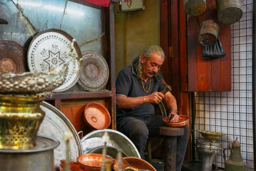 Free A master craftsman skillfully creates copper items in a traditional Gaziantep workshop, showcasing rich cultural heritage. Stock Photo