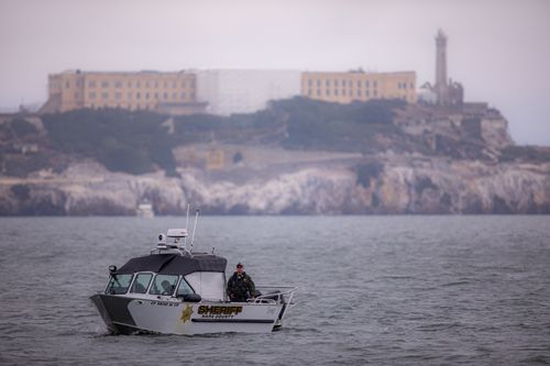 Free Sheriff boat patrols San Francisco Bay with Alcatraz Island in the background. Stock Photo