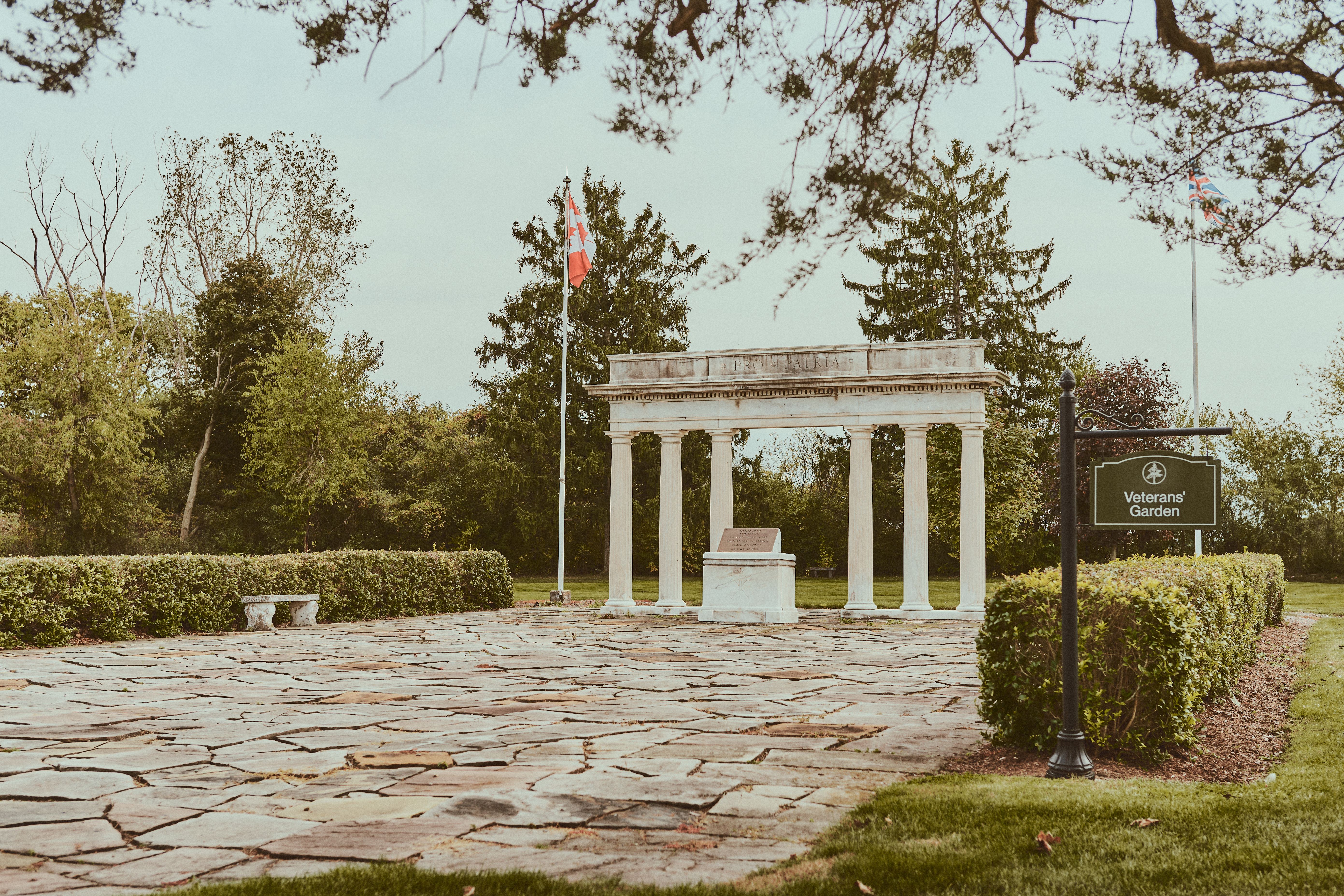 Tranquil scenery at the Veterans' Garden with a monument and autumn foliage.