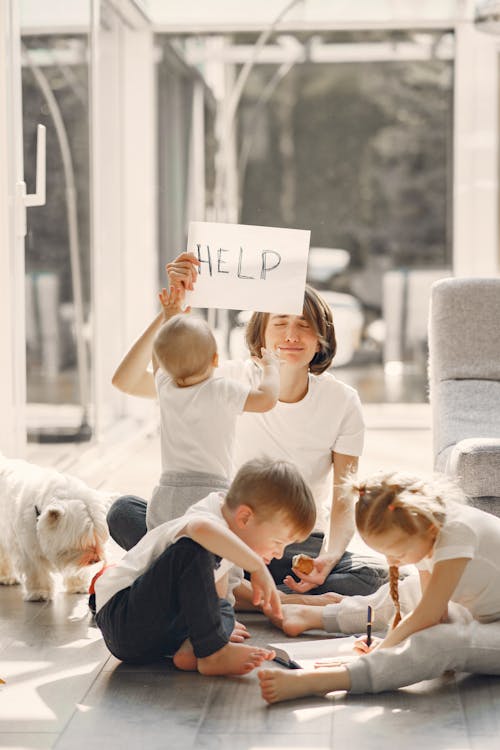 Free Tired mother kidding while sitting with children Stock Photo
