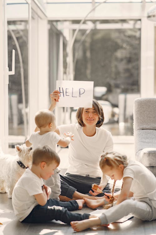 Tired mother asking for help while sitting with children