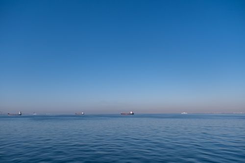 Free Tranquil blue waters and distant ships create a serene scene in the Aegean Sea, İzmir, Türkiye. Stock Photo