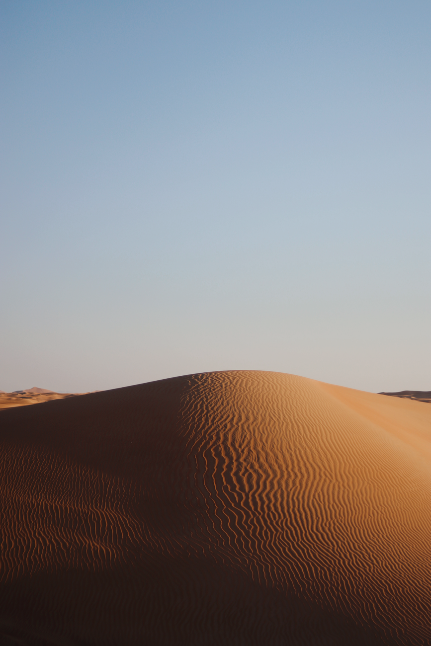 Captivating view of a sunlit sand dune with clear blue sky background, showcasing natural desert beauty.. pexels, captivating