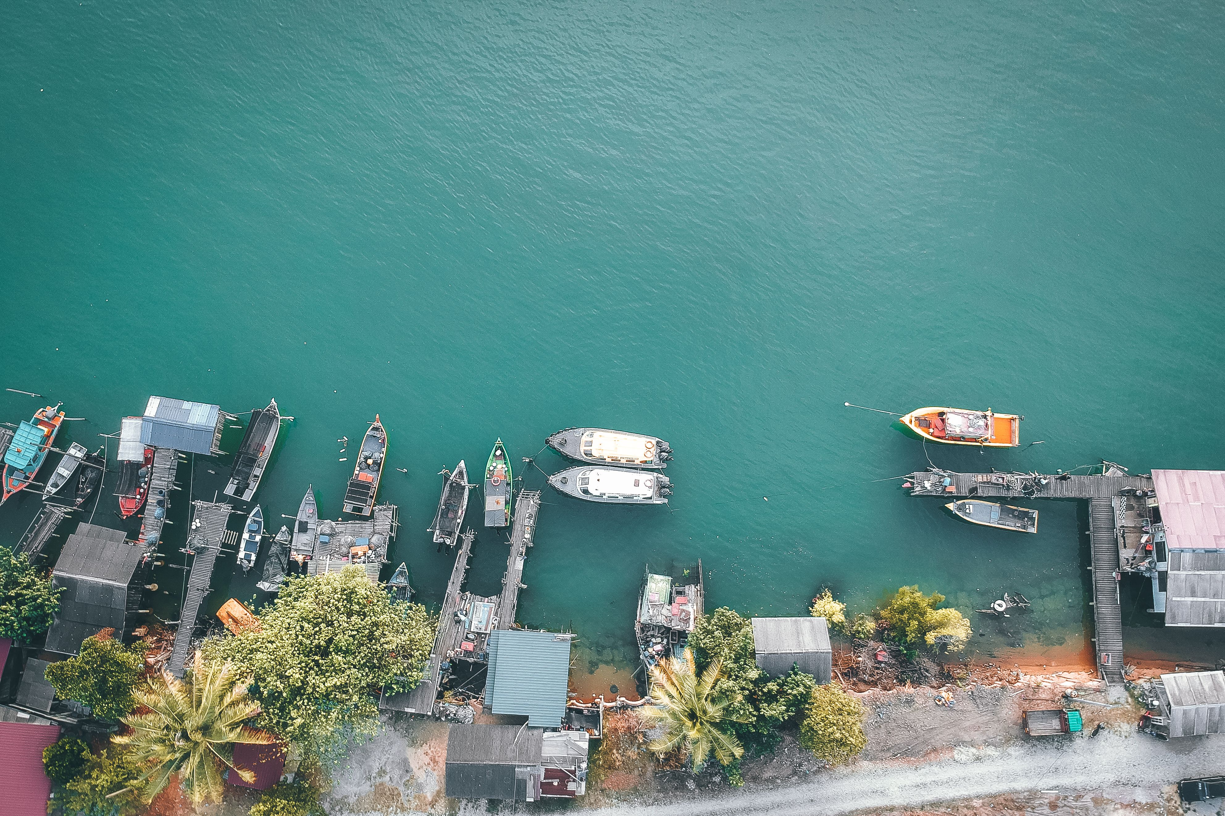 aerial view of a turquoise lagoon with a small fishing village on the shore