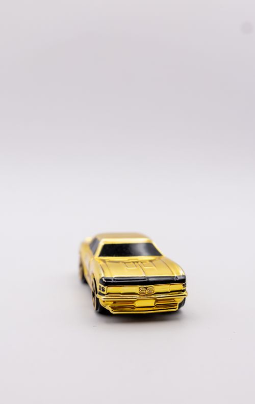 Free Close-up of a golden toy car on a simple white backdrop, highlighting its sleek design. Stock Photo