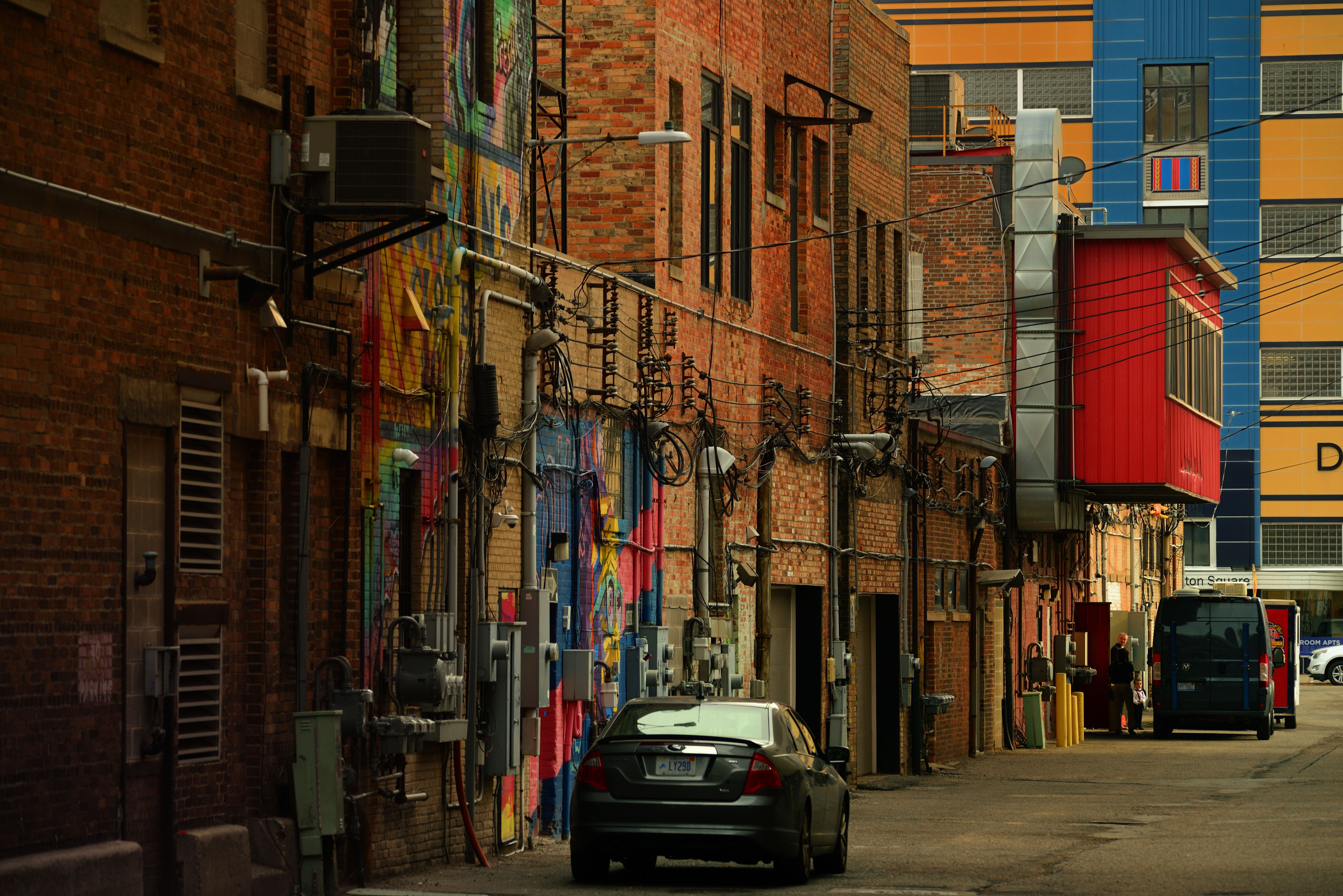 Colorful murals covering the walls of an urban alleyway.