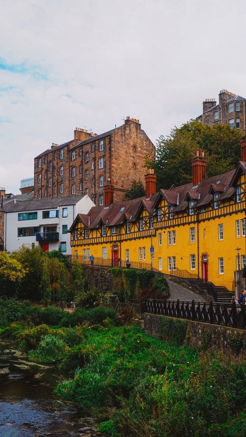 Free Picturesque view of Dean Village, Edinburgh with colorful historic buildings and lush greenery. Stock Photo