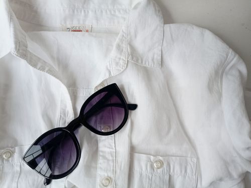 Free Flat lay of a classic white shirt and stylish sunglasses, perfect for summer fashion inspiration. Stock Photo